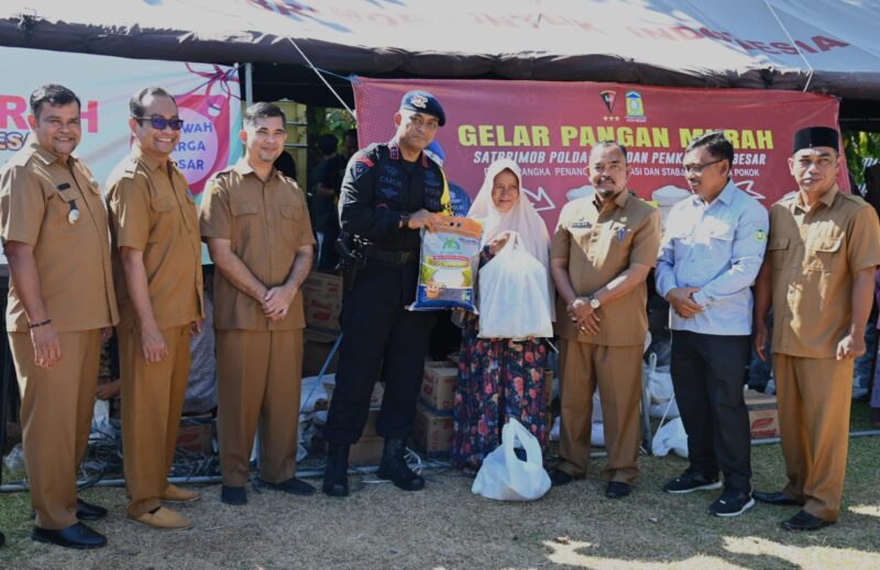 Asisten II Sekdakab Aceh Besar, M Ali, S.Sos, M.Si menyerahkan secara simbolis belanja sembako murah kepada masyarakat pada Bazar Pangan Murah yang digelar Pemkab Aceh Besar bekerjasana Satbrimob Polda Aceh dan Perum Bulog Kanwil Aceh, di Halaman Masjid Ladong, Kecamatan Mesjid Raya, Aceh Besar, Selasa (02/04/2024).