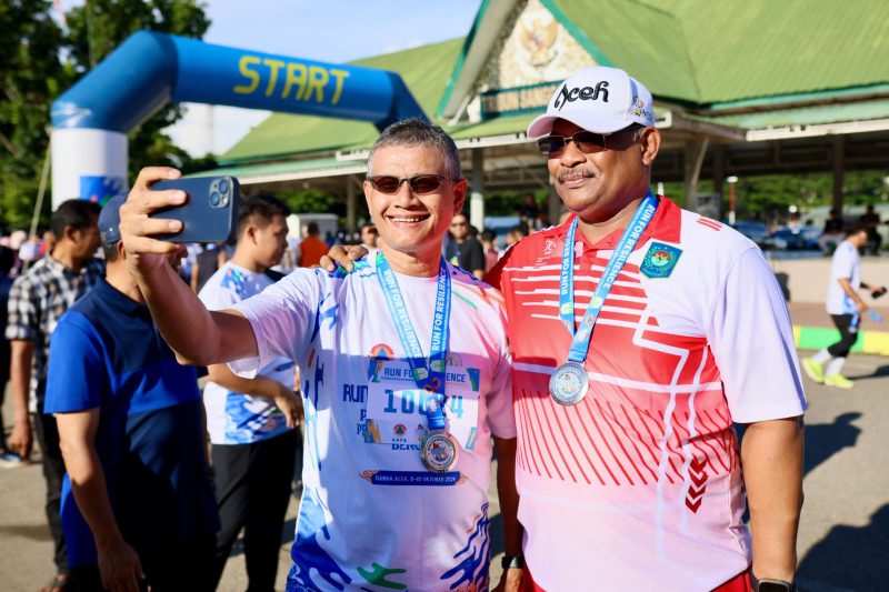 Pj Gubernur Aceh Dr, H Safrizal, ZA, M. Si bersuaphoto dengan peserta Run for Resilience dalam Rangka Peringatan Bulan PRB Tahun 2024 di Lapangan Blang Padang, Kamis 10/10/2024.