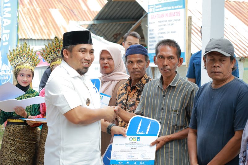 Pj Bupati Aceh Besar, Muhammad Iswanto, S.STP., MM., menyerahkan kunci rumah dhuafa berstruktur tahan gempa tipe 36 secara simbolis kepada penerima manfaat di Gampong Geundrieng, Kecamatan Darul Imarah, Aceh Besar, Minggu (02/02/2025).