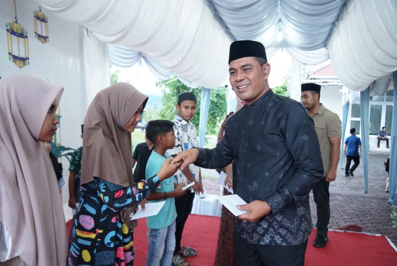 Bupati Aceh Besar H Muharram Idris bersama Istri Rita Mayasari foto bersama dengan anak yatim usai menyerahkan santunan, di Meuligo Aceh Besar, Kota Jantho, Kamis (14/03/2025) sore.