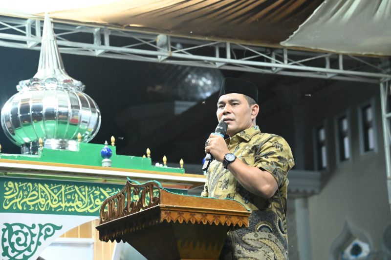 Bupati Aceh Besar H Muharram Idris (Syech Muharram) menyampaikan sambutannya dan sekaligus membuka MTQ ke-13 Tingkat Kemukiman Kueh, di halaman Masjid Al-Istiqamah Kemukiman Kueh, Kecamatan Lhoknga, Kabupaten Aceh Besar, Jumat (14/03/2025) malam.